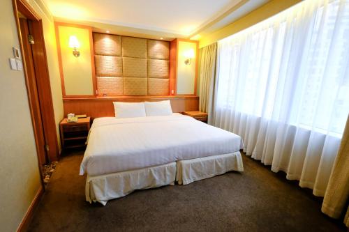 a hotel room with a large bed and a window at South Pacific Hotel in Hong Kong