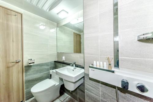 bagno con servizi igienici bianchi e lavandino di Index Hotel J Dream Jeju a Jeju