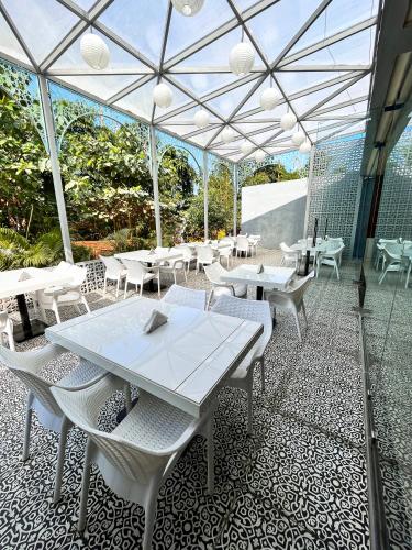 een patio met witte tafels en witte stoelen bij Olive Resort - Sillari Pench in Silāri