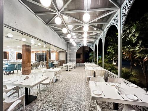 een restaurant met witte tafels en witte stoelen bij Olive Resort - Sillari Pench in Silāri