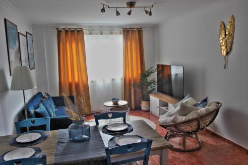 ein Wohnzimmer mit einem Holztisch und Stühlen in der Unterkunft Malpica Greek Home in Malpica