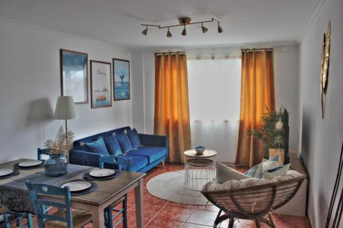 ein Wohnzimmer mit einem blauen Sofa und einem Tisch in der Unterkunft Malpica Greek Home in Malpica