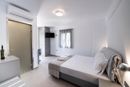 a white bedroom with a bed and a bathroom at Aurelia in Nikiana