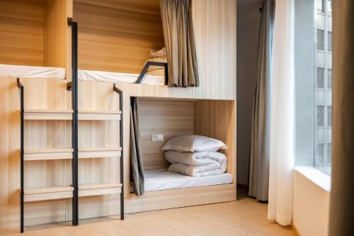 a room with two bunk beds and a window at Dayin Youth Hostel - East Nanjing Road & People's Square & The Bund -Large Social Area -Bar -Café -Gym -Free Laundry Luggage Storage -24H Front Desk -English Service in Shanghai
