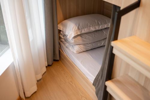 a bedroom with a bunk bed with two pillows at Dayin Youth Hostel - East Nanjing Road & People's Square & The Bund -Large Social Area -Bar -Café -Gym -Free Laundry Luggage Storage -24H Front Desk -English Service in Shanghai