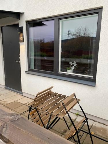 a wooden bench sitting in front of a window at Magnolia House Norrviken in Sollentuna