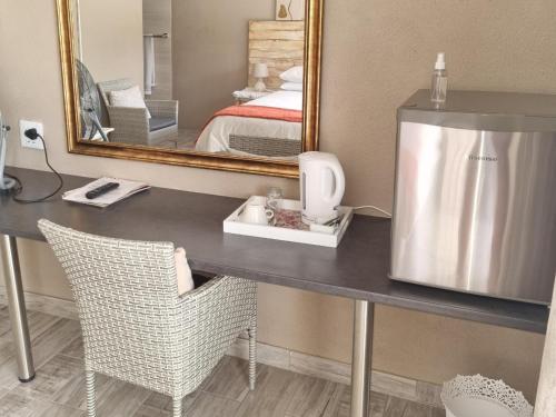 a vanity with a hair dryer on a desk in a hotel room at Northern Vine Guesthouse B&B Self-catering in Brackenfell