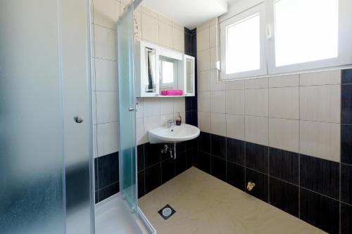 uma casa de banho com um lavatório e um chuveiro em Cozy Two-Bedroom Apartment em Zadar