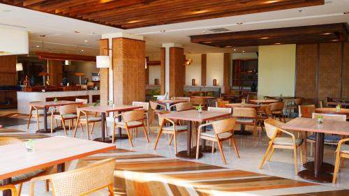 a restaurant with tables and chairs and a bar at Grand Inna Samudra Beach in Cimaja