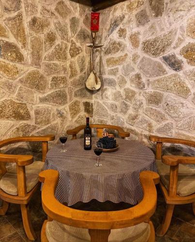 a table with two chairs and a bottle of wine at Eco Villas Merak in Virpazar
