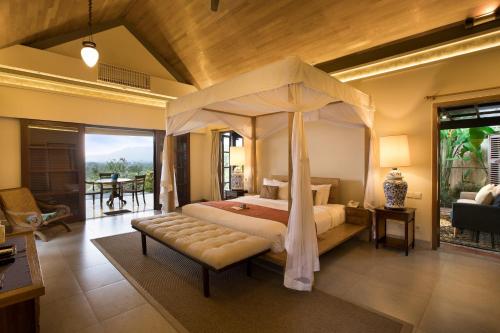a bedroom with a canopy bed and a balcony at Plataran Borobudur in Borobudur