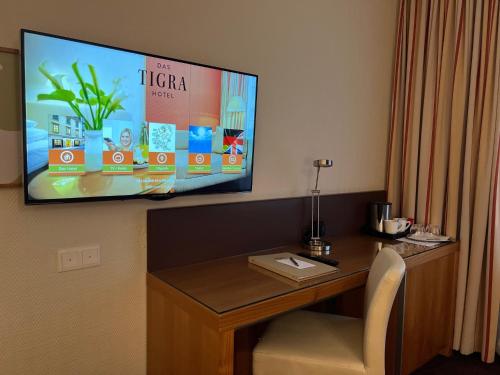 a tv hanging on a wall above a desk at Boutique Hotel Das Tigra in Vienna