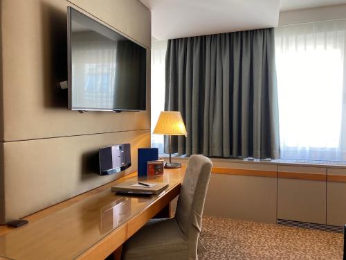 a room with a desk with a chair and a television at Boutique Hotel Das Tigra in Vienna