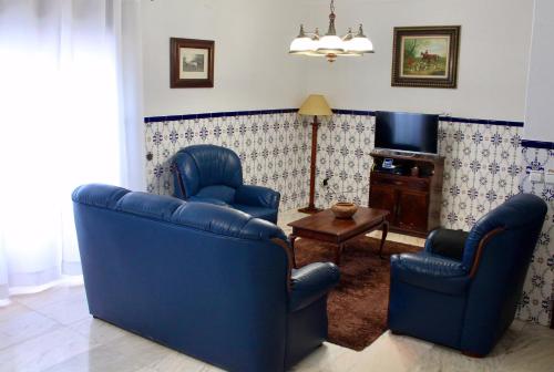 Sala de estar con 2 sillas azules y TV en Casa 33, en Veiros