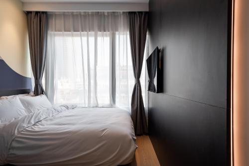 a bedroom with a bed and a large window at Dayin Youth Hostel - East Nanjing Road & People's Square & The Bund -Large Social Area -Bar -Café -Gym -Free Laundry Luggage Storage -24H Front Desk -English Service in Shanghai