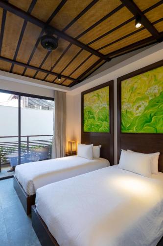 two beds in a hotel room with two beds at Nghê Prana Hotel and Spa Hoi An in Hoi An