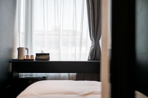 a bedroom with a bed and a window with curtains at Dayin Youth Hostel - East Nanjing Road & People's Square & The Bund -Large Social Area -Bar -Café -Gym -Free Laundry Luggage Storage -24H Front Desk -English Service in Shanghai