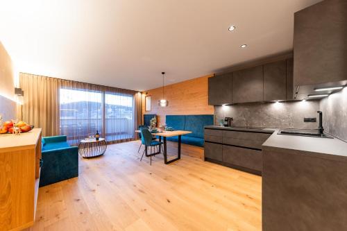 a kitchen with a table and a dining room at Rienz Alpine City Lofts in Brunico