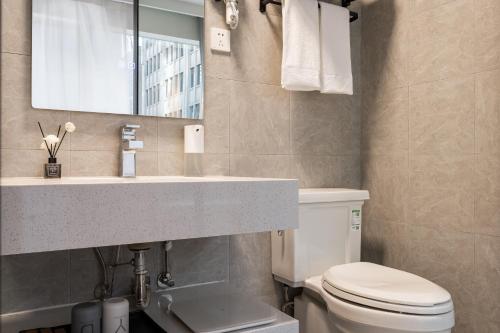 a bathroom with a sink and a toilet and a mirror at Dayin Youth Hostel - East Nanjing Road & People's Square & The Bund -Large Social Area -Bar -Café -Gym -Free Laundry Luggage Storage -24H Front Desk -English Service in Shanghai