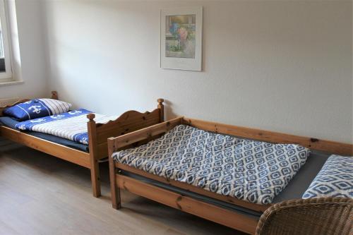 1 dormitorio con 2 camas individuales y una foto en la pared en "Pappelhof - Whg 1" en Grömitz