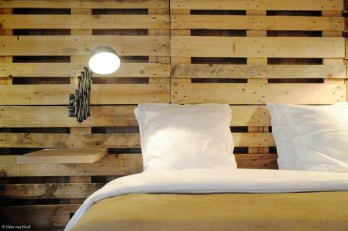 a bedroom with a wooden wall and a bed with pillows at 9Hotel Chelton in Brussels