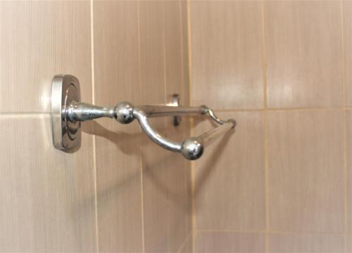 a shower door with a metal handle on a wall at Silvy Guesthouse in Canggu