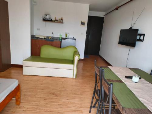 un soggiorno con divano verde e tavolo di HUGE STUDIO @ Arezzo place Davao condominium a Davao