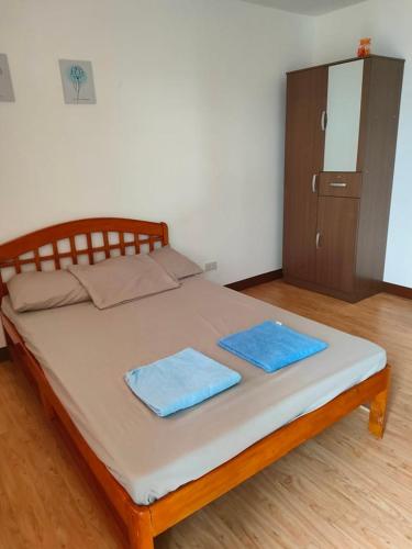 ダバオシティにあるHUGE STUDIO @ Arezzo place Davao condominiumの青いタオル2枚が備わるドミトリールームのベッド1台分です。