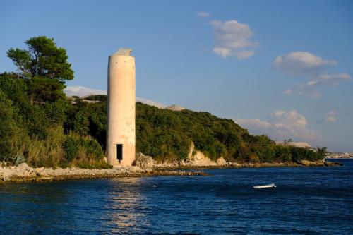 a lighthouse in the middle of a body of water at Modern Oceanview in Metajna