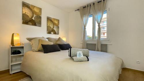 a bedroom with a large bed with a phone on it at HOMEY WOOD - New - Appartement avec une chambre - Parking privé gratuit - Balcon privé - A 5 min de la gare pour rejoindre Genève in Annemasse