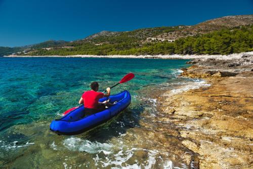 a man in a blue kayak in the water at Modern Oceanview in Metajna
