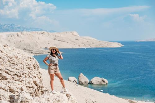 a woman standing on a cliff near the ocean at Modern Oceanview in Metajna