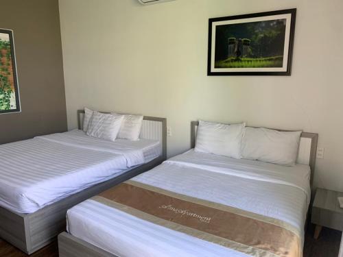 two beds sitting next to each other in a room at Alina Retreat in Hiếu Nhơn