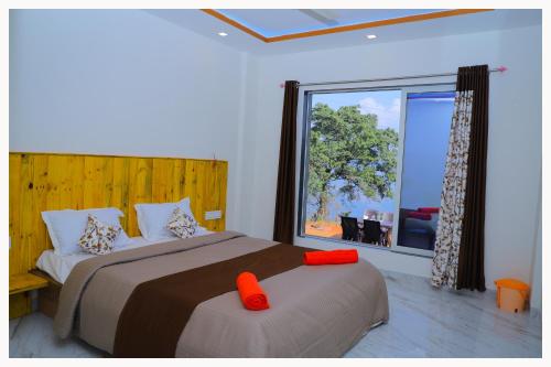 a bedroom with two beds and a large window at Sai Siddhigiri Villa in Mahabaleshwar