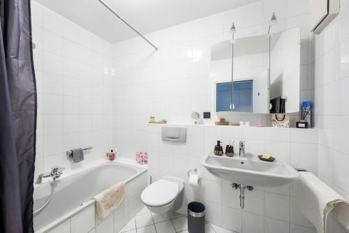 a white bathroom with a tub and a toilet and a sink at Komfort Deluxe in Ludwigshafen am Rhein