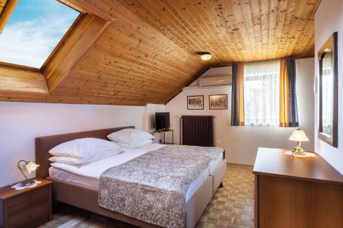 a bedroom with a bed and a wooden ceiling at Lake Bled Apartment Zerovec in Bled
