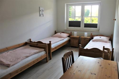 グレーミッツにある"Pappelhof - Whg 2"のベッド2台、テーブル、窓が備わる客室です。