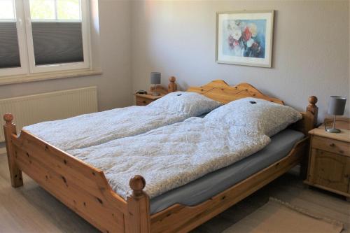 um quarto com uma cama com uma estrutura em madeira em "Pappelhof - Whg 3" em Grömitz