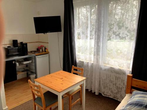 ein kleines Zimmer mit einem Tisch und einem Fenster in der Unterkunft Mini Apartment in Osterholz-Scharmbeck