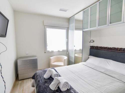 sypialnia z łóżkiem i ręcznikami w obiekcie Precioso apartamento reformado en el sardinero w mieście Santander