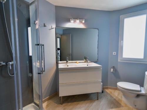 y baño con lavabo, ducha y aseo. en Precioso apartamento reformado en el sardinero, en Santander
