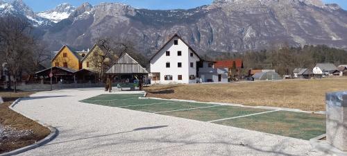 a large white building with mountains in the background at Guest house Vila Korošec in Bovec