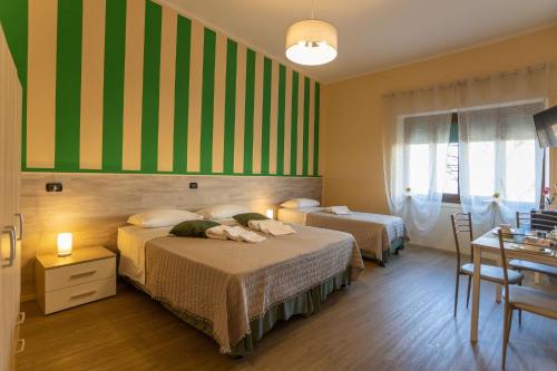 duas camas num quarto com riscas verdes e amarelas em L'OPERA ROOMS em Verona