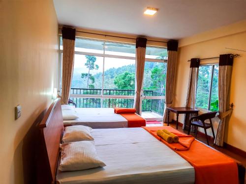a room with three beds and a balcony with a window at Hotel Olinka in Haputale