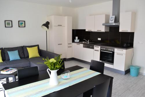 eine Küche und ein Wohnzimmer mit einem Sofa und einem Tisch in der Unterkunft Ferienwohnung Rockside in Arnoldstein