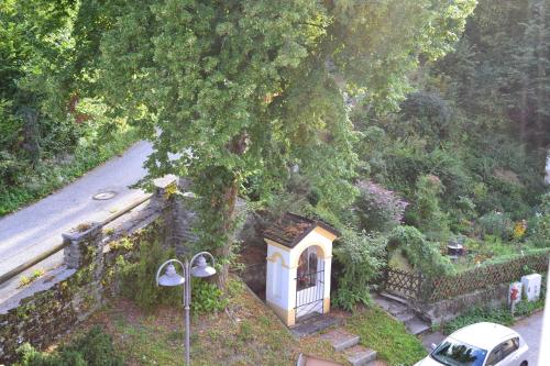 a small house under a tree next to a road at Ferienwohnung Rockside in Arnoldstein