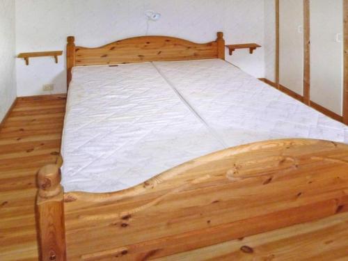 uma grande cama de madeira num quarto com pisos de madeira em Apartment STRYN II em Stryn