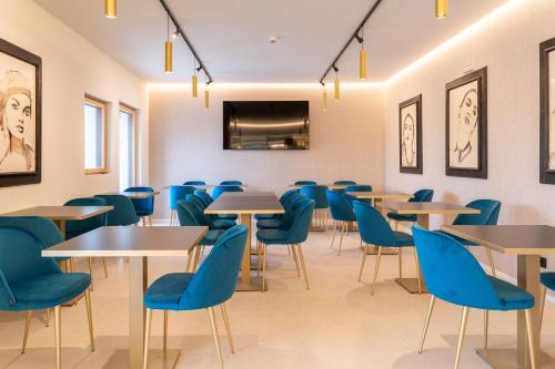 a dining room with tables and blue chairs at Relais Forte Benedek Wine & SPA - Adults Only in Pastrengo
