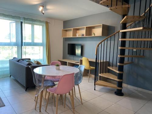 - un salon avec une table et des chaises ainsi qu'un escalier dans l'établissement LOFT DIONYSIEN DE STANDING, à Saint-Denis