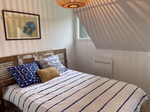 Schlafzimmer mit einem Bett mit blauer und weißer Bettwäsche in der Unterkunft 250 m des plages - Jardin - WIFI - Velos - in Carnac